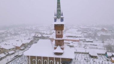Aerial video of the wooden church at Sapanta cemetery in Maramures county, Romania in winter season. Footage was done from a drone while flying towards the church and picking up altitude.