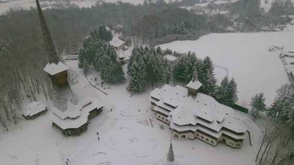 冬季在罗马尼亚马拉穆尔县Sapanta Peri的木制教堂的空中录像 录像是从一架无人驾驶飞机上拍的 当时飞机在低空飞行 并在教堂和风景上空向前飞去 — 图库视频影像