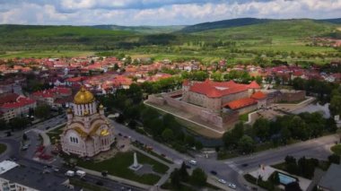 Aerial footage of the Citadel of Fagaras, in Brasov county, Romania. Video was shot from a drone with camera tilted downwards at a lower angle. Birds eye view over medieval fort.
