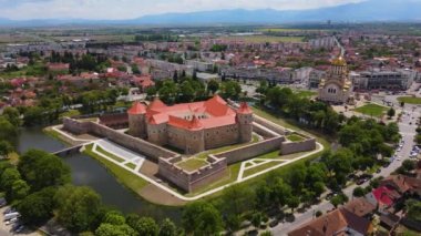 Aerial footage of the Citadel of Fagaras, in Brasov county, Romania. Video was shot from a drone with camera tilted downwards at a lower angle. Birds eye view over medieval fort.