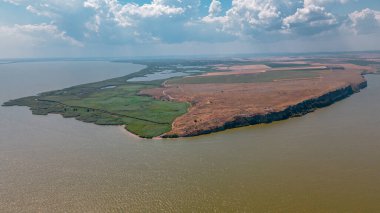 Romanya 'nın Tulcea ilinde bulunan Argamum kalesi ile birlikte Razim Gölü' nün kıyısındaki Dolosman Burnu 'nun havadan görünüşü. Fotoğraf, gün ortasında güneşli bir havada, yaz mevsiminde bir İHA 'dan çekildi..