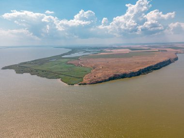Romanya 'nın Tulcea ilinde bulunan Argamum kalesi ile birlikte Razim Gölü' nün kıyısındaki Dolosman Burnu 'nun havadan görünüşü. Fotoğraf, gün ortasında güneşli bir havada, yaz mevsiminde bir İHA 'dan çekildi..