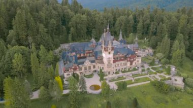 Romanya 'nın Sinaia kentindeki Peles kalesinin panoramik manzarası. Görüntüler, saat yönünün tersine binanın etrafında uçarken kaleyi gören bir İHA tarafından çekildi..