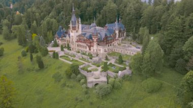 Sinaia Romanya 'daki Peles Kalesi' ne kuşların bakış açısı. Hava görüntüsü bir İHA 'dan çekildi ileri doğru uçarken ve kaleye yaklaşırken sola yatarken..