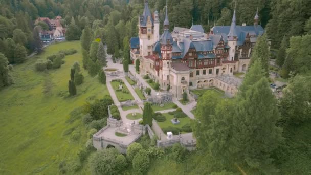 在罗马尼亚Sinaia的Peles城堡上空鸟瞰 录像是在低空飞行时从一架无人驾驶飞机上拍摄的 飞机在低空飞行时 正好在树的上方 将摄像机向上倾斜 以揭示城堡 — 图库视频影像