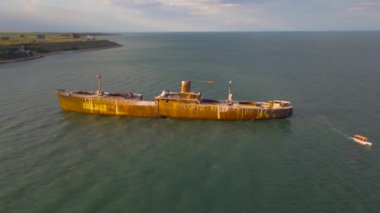 Romanya 'nın Costinesti plajının yanındaki Karadeniz' de paslı bir gemi enkazının insansız hava aracı görüntüleri. İHA 'dan çekilen hava görüntüsü enkazdan uzaklaşırken geriye doğru uçuyor..