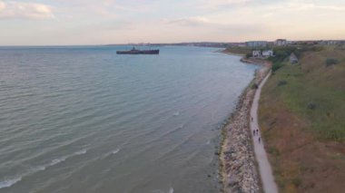 Romanya 'nın Köstence kentindeki Costinesti sahilinin güzel manzara görüntüleri. Video günbatımında bir İHA 'dan çekildi. Arka planda gemi enkazı ve sahilde motorcular vardı..