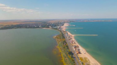 Plajın sol tarafında Techirghiol Gölü ve sağ tarafında Karadeniz olan Eforie sahilindeki bir drondan çekilen hava görüntüsü. Deniz ve göl arasında bir kara parçası.