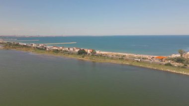 Eforie sahilindeki Techirghiol Gölü 'nün arka tarafında ve Karadeniz' in ön tarafında çekildiği bir drondan alınan hava görüntüsü. Göl ve deniz arasında bir kara parçası görünüyor..