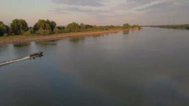 Tuna 'nın deltasındaki Sulina Kanalı' nın hava görüntüleri, bir motorlu tekne ve güzel bir gündoğumu manzarası ile uçarken drone tarafından çekildi. Video, bir yandan tekneyi kovalarken bir drondan çekilmiş..