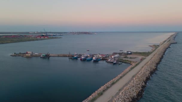 漁船が停泊している港の空中ビュー ルーマニアのナヴォダリ港の日没の夏の季節に より高い高度のドローンから撮影されました — ストック動画