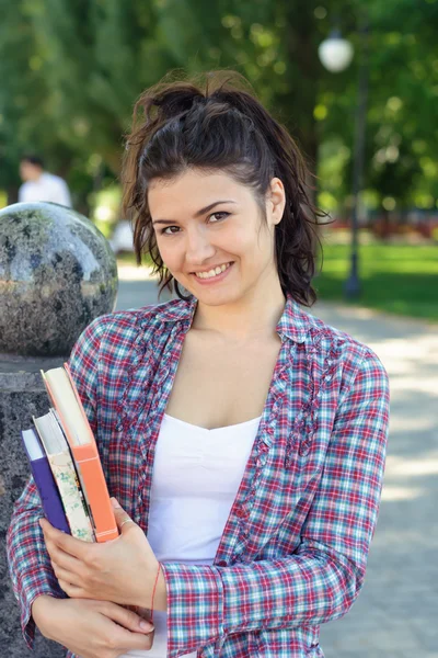 Menina estudante segurando um livro em suas mãos . — Fotografia de Stock