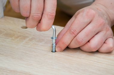 Metal bir mobilyayı vidalayan kadın eli. Tornavidayla vida. Kadın dairede kendi başına mobilya topluyor. Mobilya montajı, ev işi, DIY.