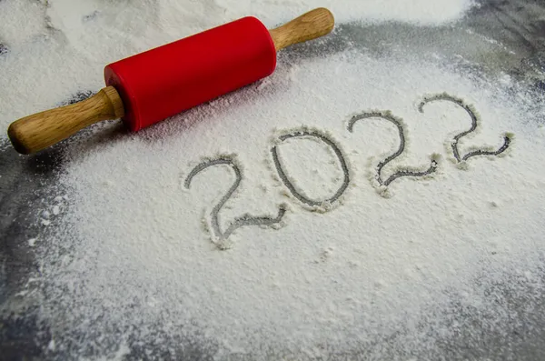 2022年的标志画在面粉上 2022年的铭文是由黑色混凝土背景的面粉制成的 文字空间 滚动销 面粉和编号2022 圣诞烹饪背景 — 图库照片#