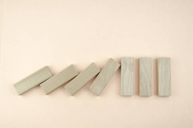 Düşen tahta bloklar duvara çarpıyor. Güç, liderlik, direniş kavramı. Tahta küpler domino taşları gibi düşer, bir blok ayakta durur..