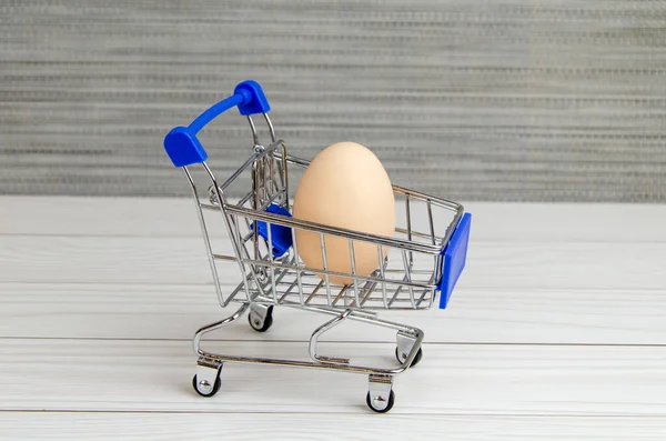 鶏の卵でいっぱいの食料品のカート バスケットに卵入りスーパートロリー イースターの準備食料の購入農業の支援 テキストのスペース — ストック写真
