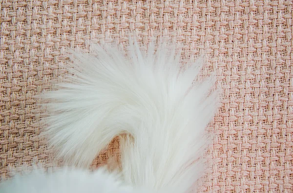 Пушистый Белый Кошачий Хвост Крупным Планом Фоне Розового Вязаного Пледа — стоковое фото