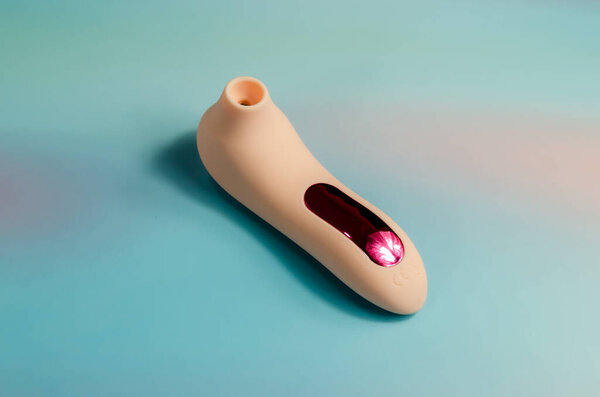 pink vacuum wave vibrator for clitoris stimulation. Sex toy for women on a light blue background. Sex shop product, for adults. space for text