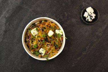 Sağlıklı vejetaryen kasesi, kırmızı mercimek, beyaz peynir ve koyu arka planda izole edilmiş yeşillikler. Gıda dağıtım hizmeti ve günlük istihkak kavramı.