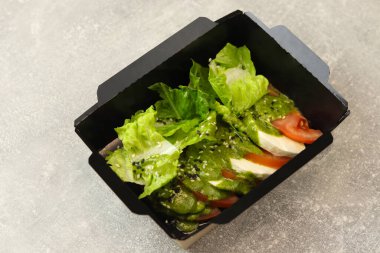 Taze İtalyan caprese salatası mozzarella ve gri arka planda domatesler..