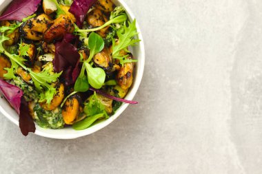 Midyeli salata, roka ve gri arka planda yuvarlak paket kağıdı kabında yeşiller. Sağlıklı yemek teslimatı konsepti. Pankart. Üst Manzara. Metin için boş alan.