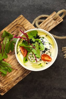 Krema soslu patates püresi, domates ve pancar yaprakları tahtadaki kağıt kabın içinde koyu arka planda izole edilmiş. Sağlıklı gıda dağıtım hizmeti ve günlük istihkak kavramı.