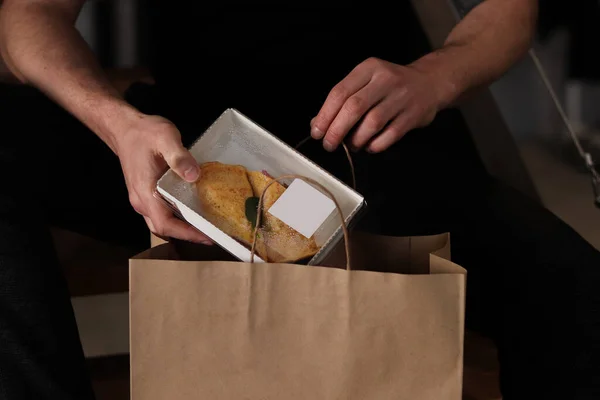 Kuryeyle eve getirilen sağlıklı kutuları açan ve birlikte yemek yemeye hazır bir adam. Sağlıklı gıda dağıtım hizmeti ve günlük istihkak kavramı.