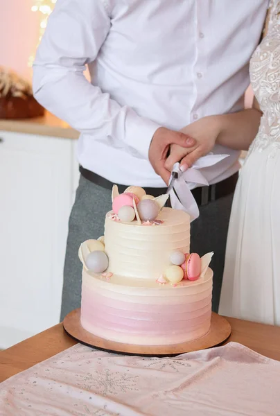 Bir gelin ve bir damat düğün pastalarını kesiyor. Düğün konsepti.