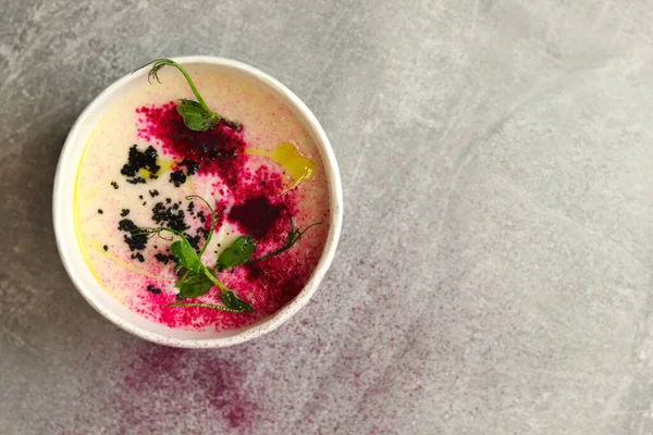 Karnabahar püre patates çorbası gri arka planda yuvarlak kasede, üst manzara. Vejetaryen sağlıklı yemek teslimatı konsepti