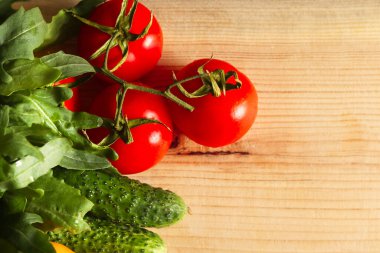 Kırsal bir ahşap masaya yayılmış taze sebze ve otların lezzetli çeşitliliğinin genel manzarası..