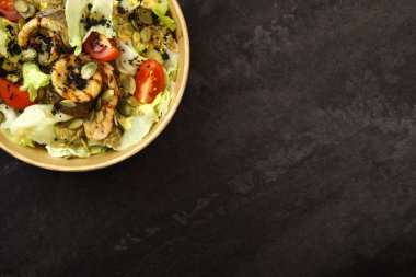 Balıklı salata. Fırında balık filetosu ile taze sebze salatası. Kızarmış fileto ile balık salatası ve koyu arka planda eko kağıt kasede taze sebzeler. Gıda dağıtım hizmeti ve günlük istihkak kavramı.