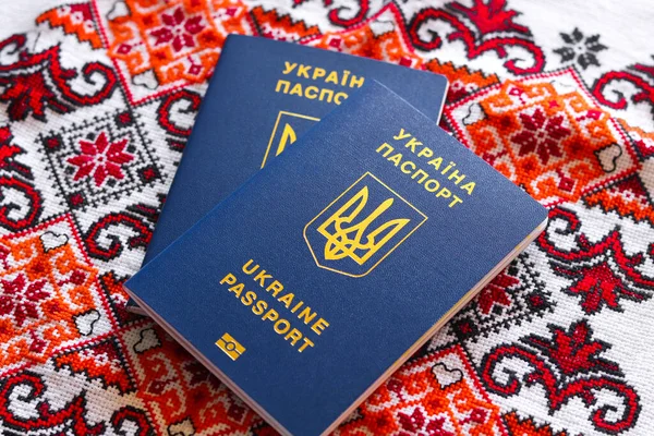 Ukrayna biyometrik pasaportları. Ulusal süslemeli nakışlı bir havluyla Ukrayna uluslararası pasaportu.