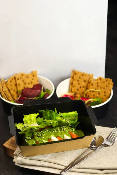 Lunch boxes with food ready for work or school, pre-cooking or diet. Healthy food delivery service and daily ration concept.Hummus. A dish of crushed chickpeas. Italian caprese salad with mozzarella