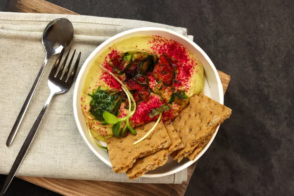 Humus. Teslimat için bir tabak ezilmiş nohut ya da internet mağazası. Karanlık bir geçmişle izole edilmiş. Sağlıklı yemek teslimatı konsepti..