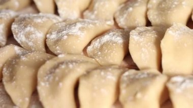 Ev yapımı vareniki veya ahşap masada patates püresi ile doldurulmuş hamur tatlısı. Patatesli çiğ hamur köftesi pişirmek. Süper manzara, kırsal tarz. Ukrayna ulusal yemeği.