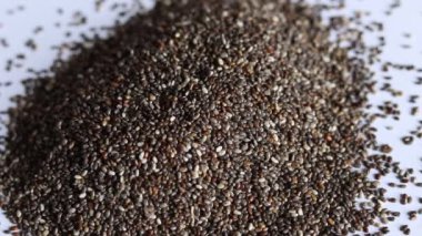 Yakın plan chia tohumları masaya düşüyor. Kuru, sağlıklı malzeme..