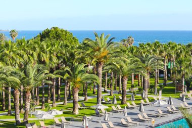 Side, Turkey - 14 Mayıs 2021: Miramare Beach Hotel 'in güzel toprakları. Dinlenme alanında yüzme havuzu. Mavi berrak su, güneş yatakları ve etrafında palmiye ağaçları.