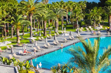 Side, Turkey - 14 Mayıs 2021: Miramare Beach Hotel 'in güzel toprakları. Dinlenme alanında yüzme havuzu. Mavi berrak su, güneş yatakları ve etrafında palmiye ağaçları.