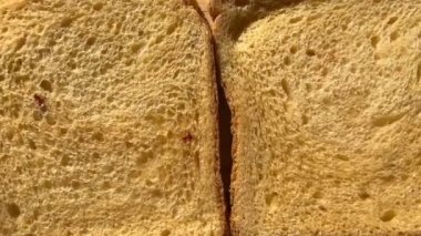 Dilimlenmiş ekmek ve ahşap mutfak tahtasındaki kurutulmuş domatesler. Yakın plan..
