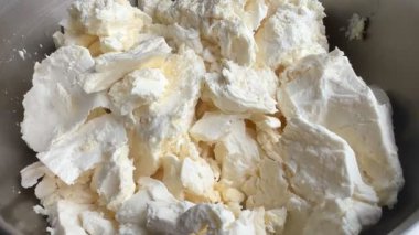 Tabakta süzme peynir yığını. Metal bir kasede organik ev yapımı süzme peynir manzarası. Taze çiftçinin süzme peynir yüzeyi. Sağlıklı gıda konsepti.