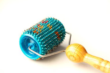 Beyaz arka planda metal iğneli tekerlekli masaj aleti. Kan dolaşımını iyileştirmek için mikronedles ile tıbbi aplikatör. Massager silindiri Lyapko.