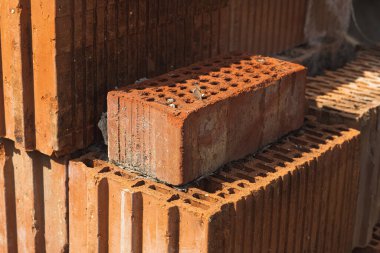 Bir yığın kil tuğla. İnşaat için malzeme..