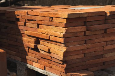 Bir yığın kil tuğla. İnşaat için malzeme..