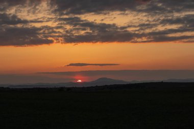 Kırsal alanda güzel bir gün batımı, arka planda dağlar. Yüksek kalite fotoğraf