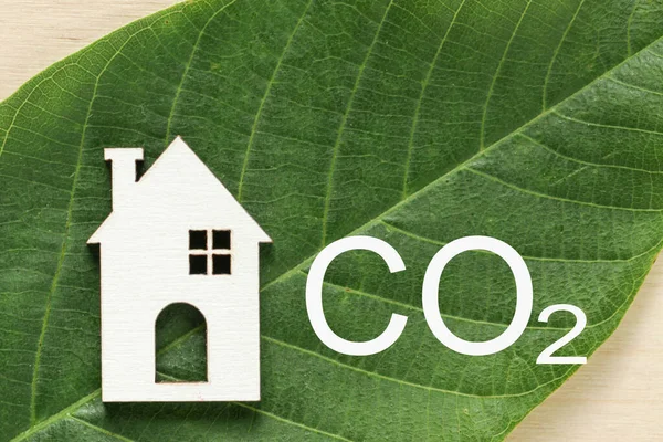 Emlakçılığın arındırılması. Karbondioksit salınımını düşür ve karbonu azalt. Ahşap Ev, yeşil yapraklı karbondioksit. Sürdürülebilir kalkınma, çevre koruma — Stok fotoğraf