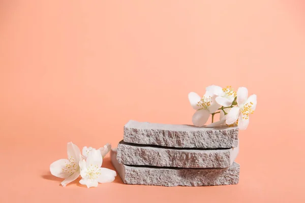 Product podium, grungy concrete stone, flower. Minimal coral background for cosmetics or products presentation. Front view.