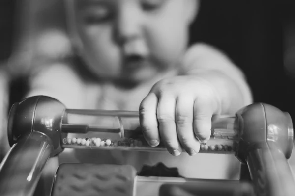 Black and white close up of baby playing with toy — Stock Photo, Image