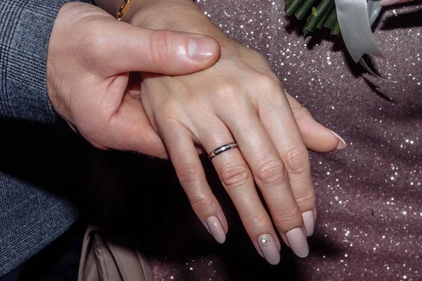 Руки молодых людей с обручальными кольцами. Детали свадьбы. Цветы каллы. супруги — стоковое фото