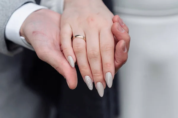 Mãos de jovens com alianças de casamento. detalhes do dia do casamento. calla flores. cônjuges — Fotografia de Stock