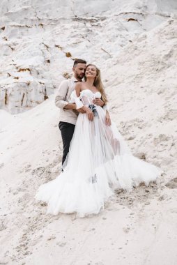 Güzel bir çift gelin ve damat, düğün günü okyanus sahilinde. Mutlu evlilikler.